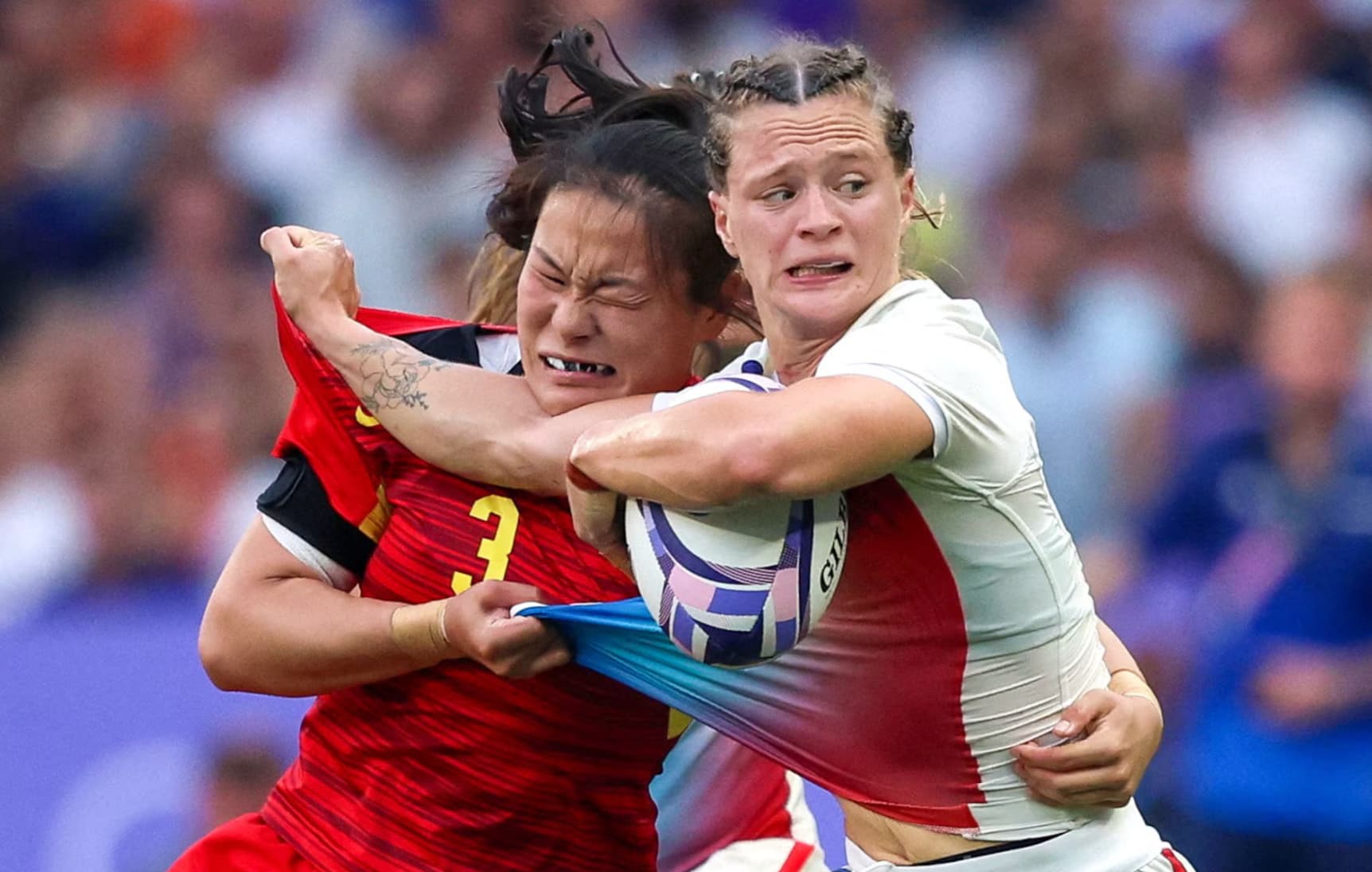 Athletes from France and China’s women’s rugby teams go at it during a match. 